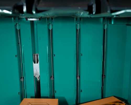 inside of a teal baler with wire channels at back