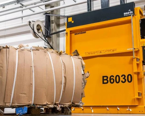 yellow b6030 vertical baler with a finished cardboard bale in front